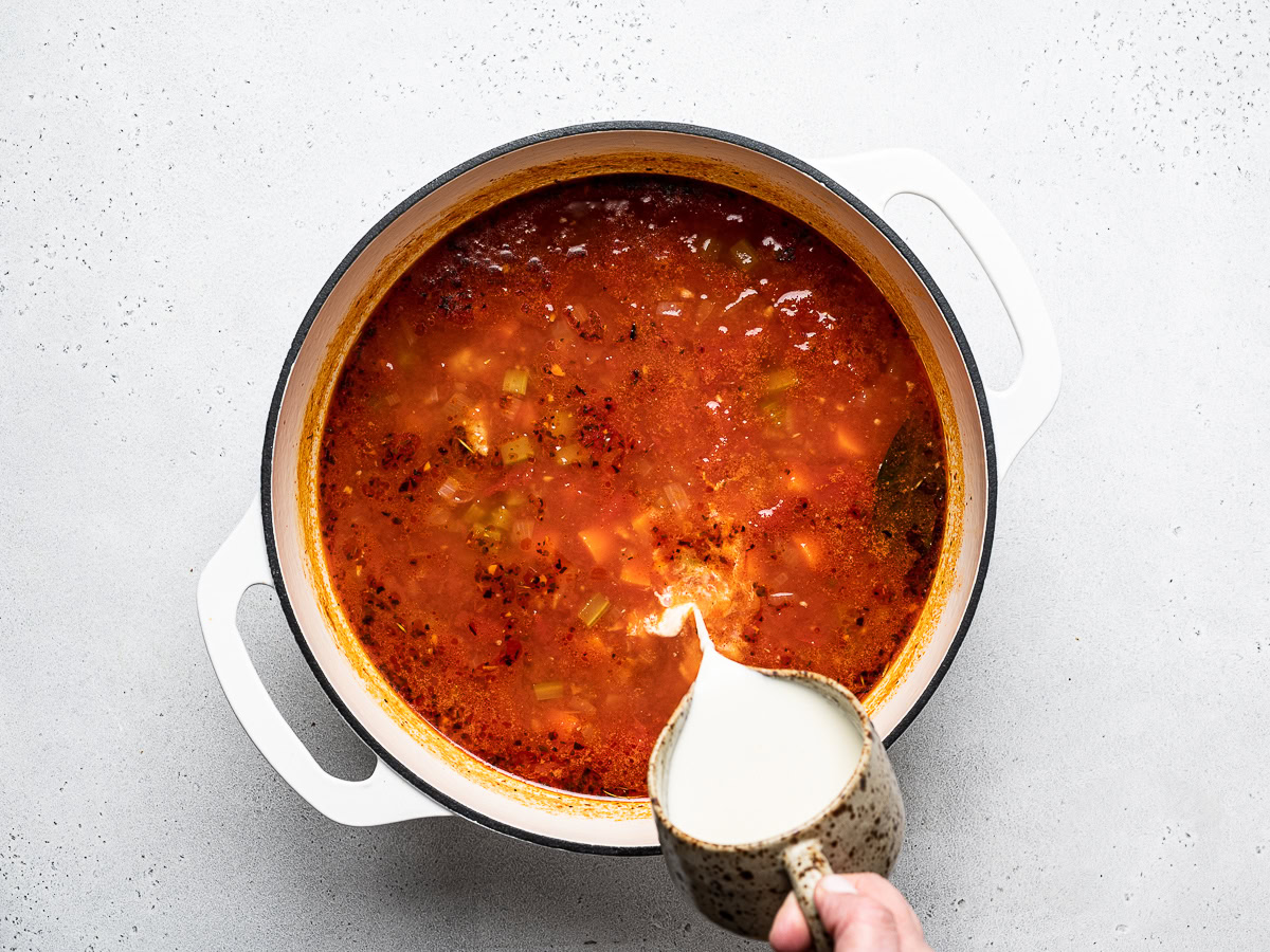 pouring the cream into soup broth base