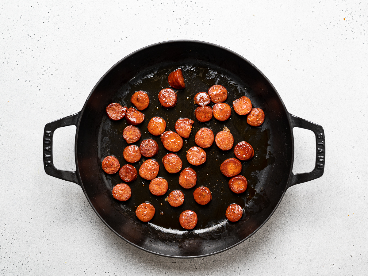 coins of chorizo sausage cooking in skillet