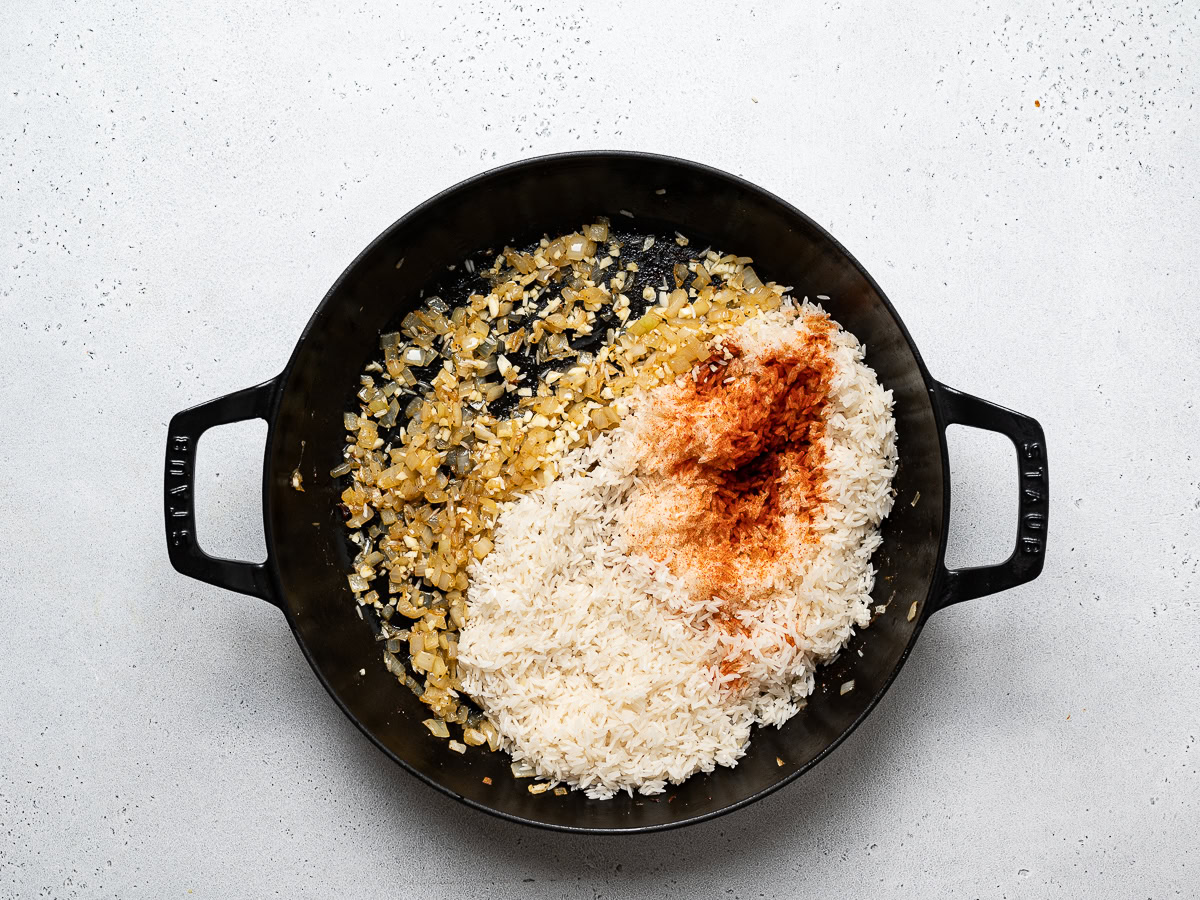 sautéing onions, garlic, rice and spices in skillet