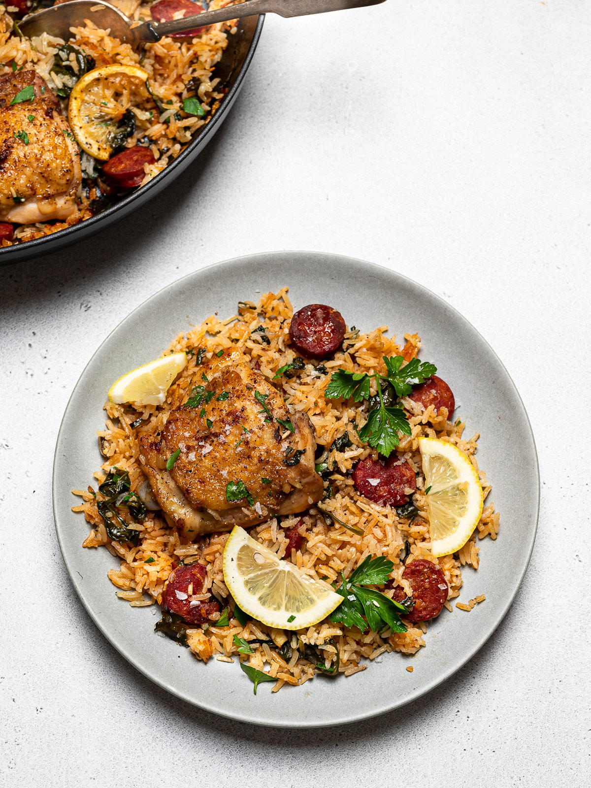 chicken and chorizo rice served on a plate with some of the skillet showing beside it