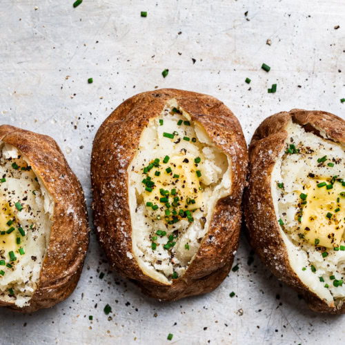 baked potato topped with cracked black pepper, butter and chives
