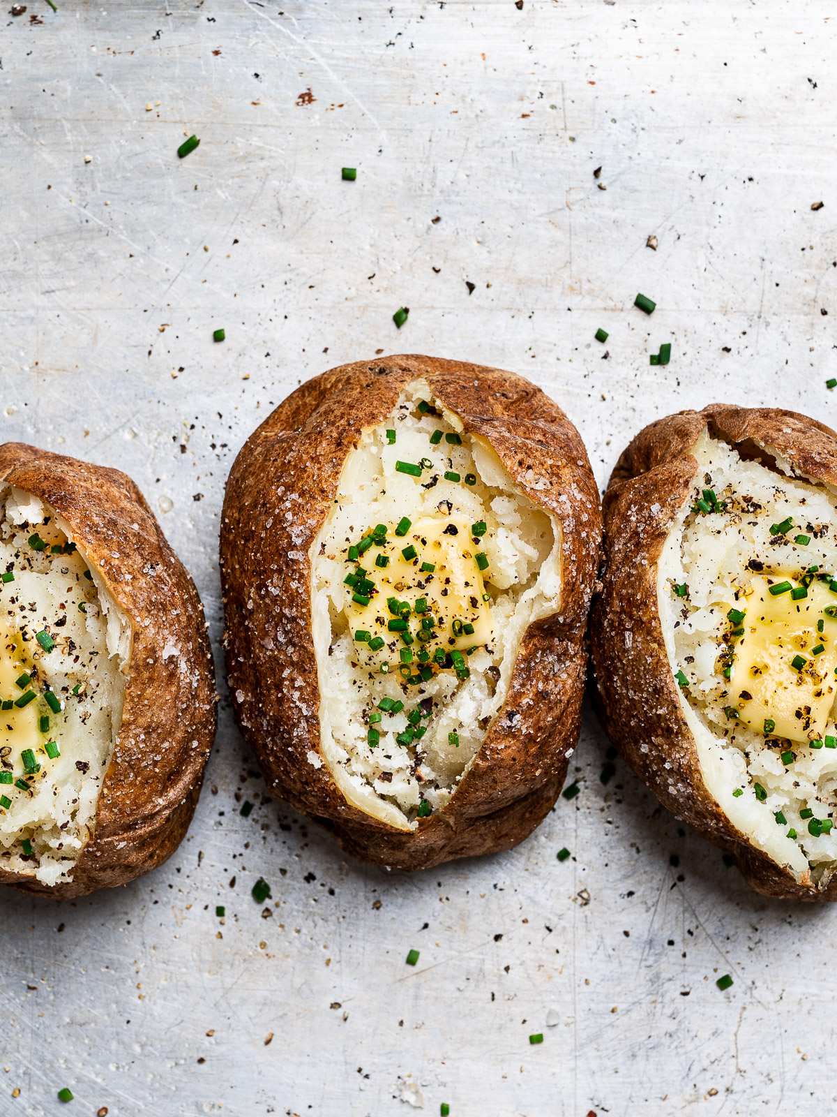 baked potato topped with cracked black pepper, butter and chives