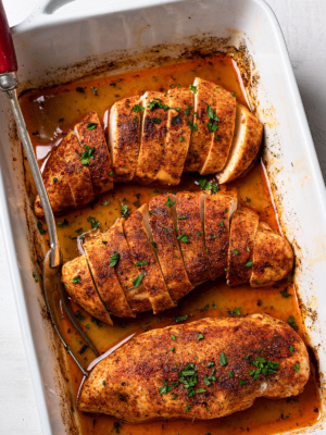 close up of sliced chicken breasts in baking dish