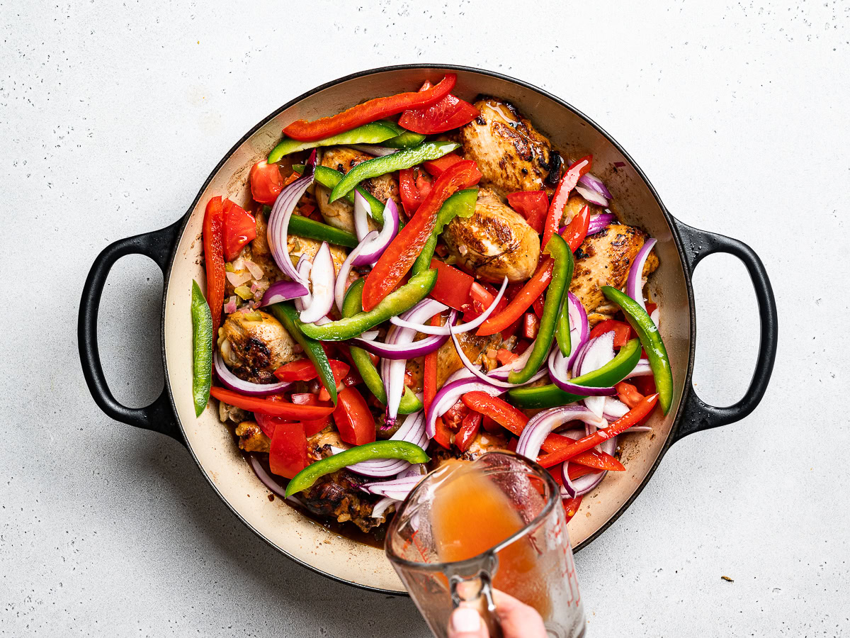 adding tomato paste dissolved in water to chicken in skillet