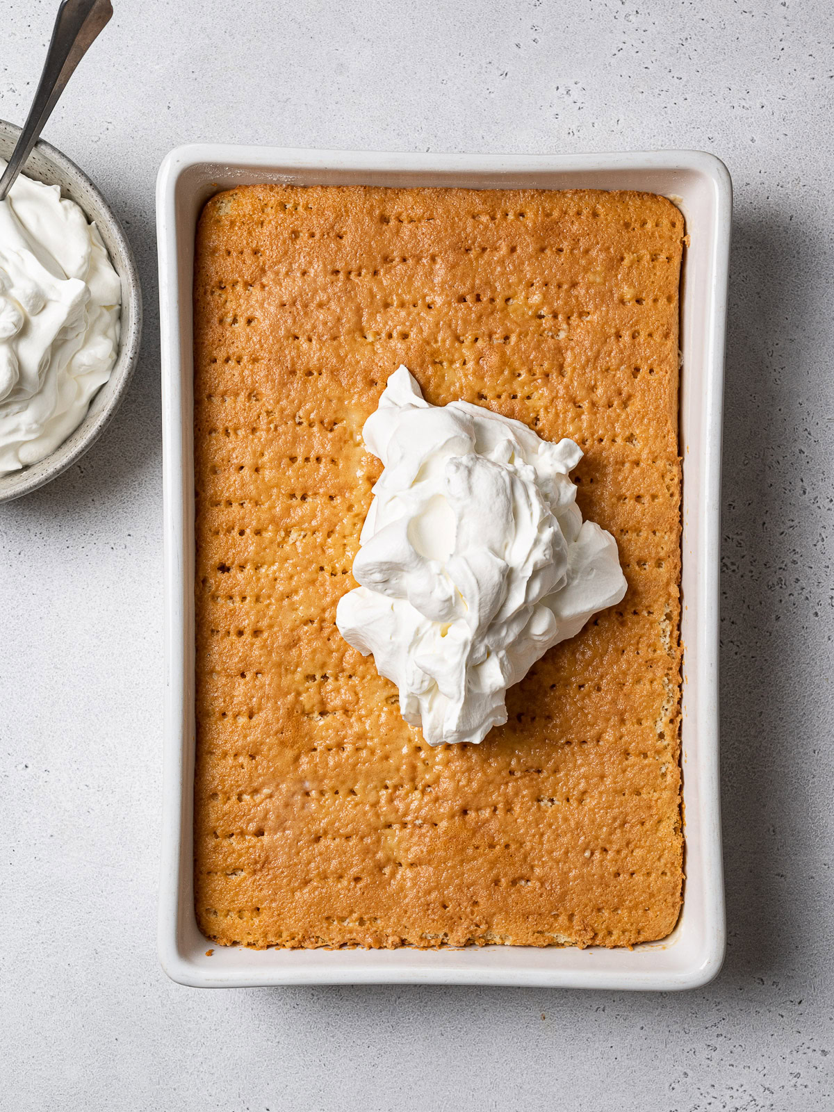 a few spoonfuls of whipped cream on top of the soaked sponge cake