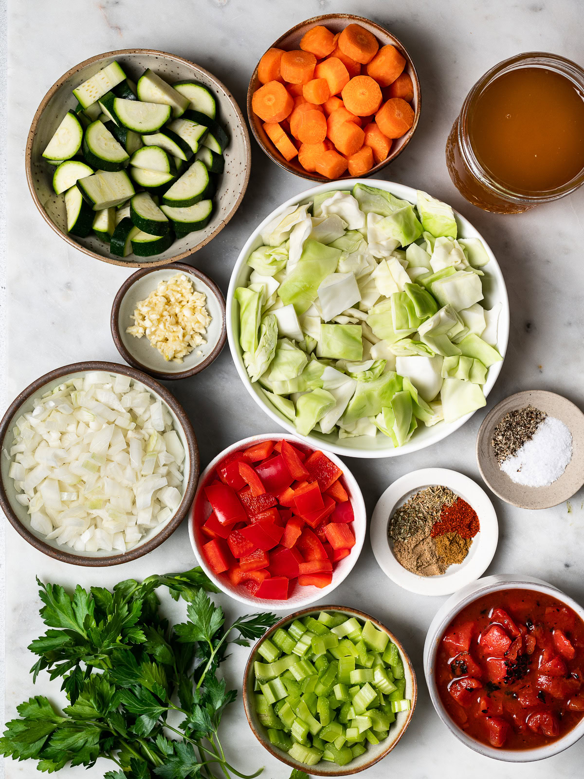 ingredients for cabbage soup set out in individual bowls 