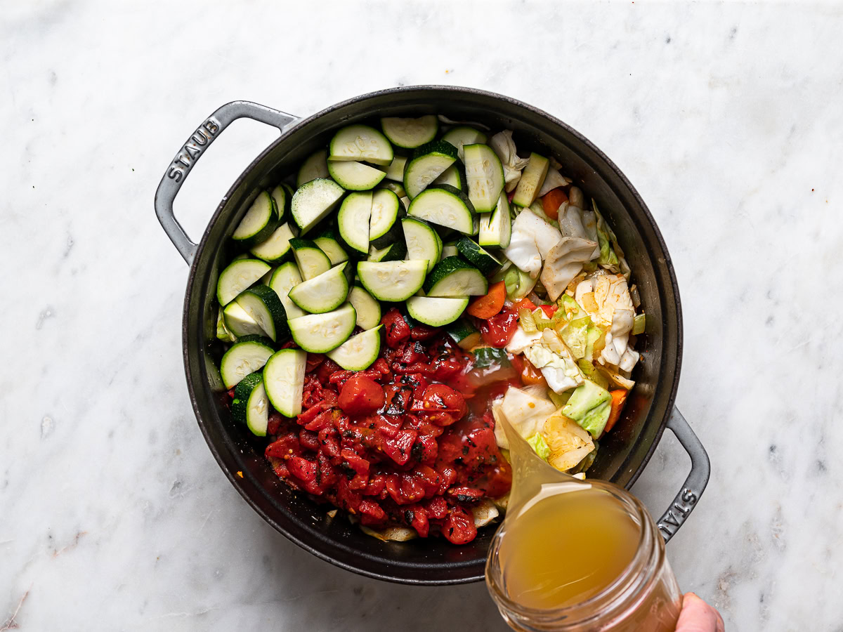 zucchini, tomatoes and broth added to soup pot