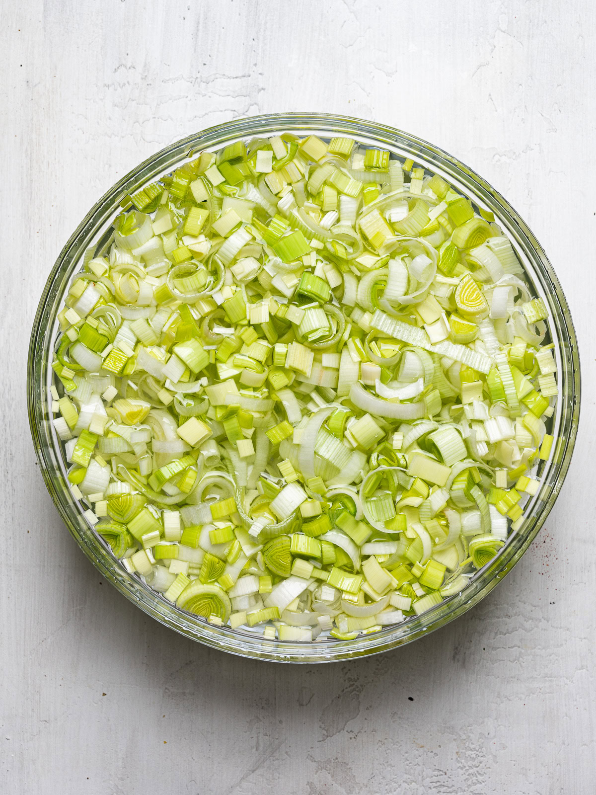 washing chopped leeks in large bowl 