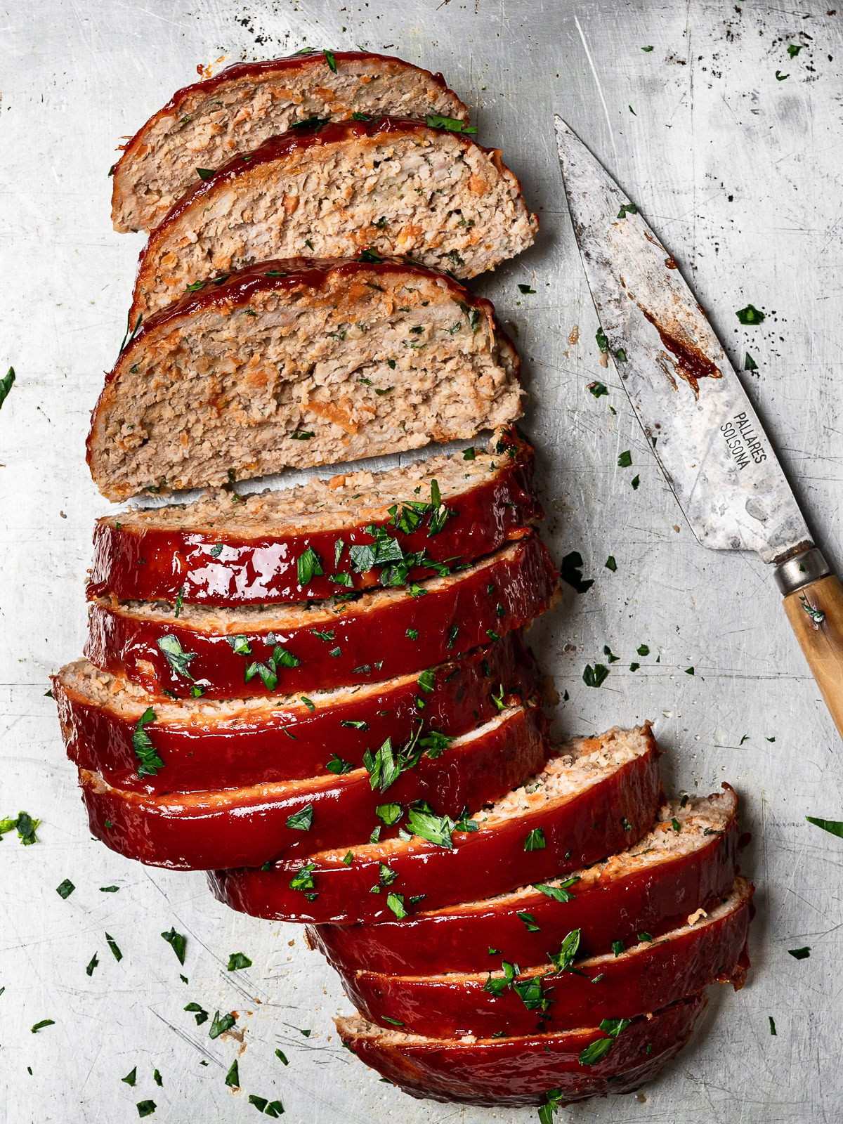 sliced turkey meatloaf on baking sheet with knife