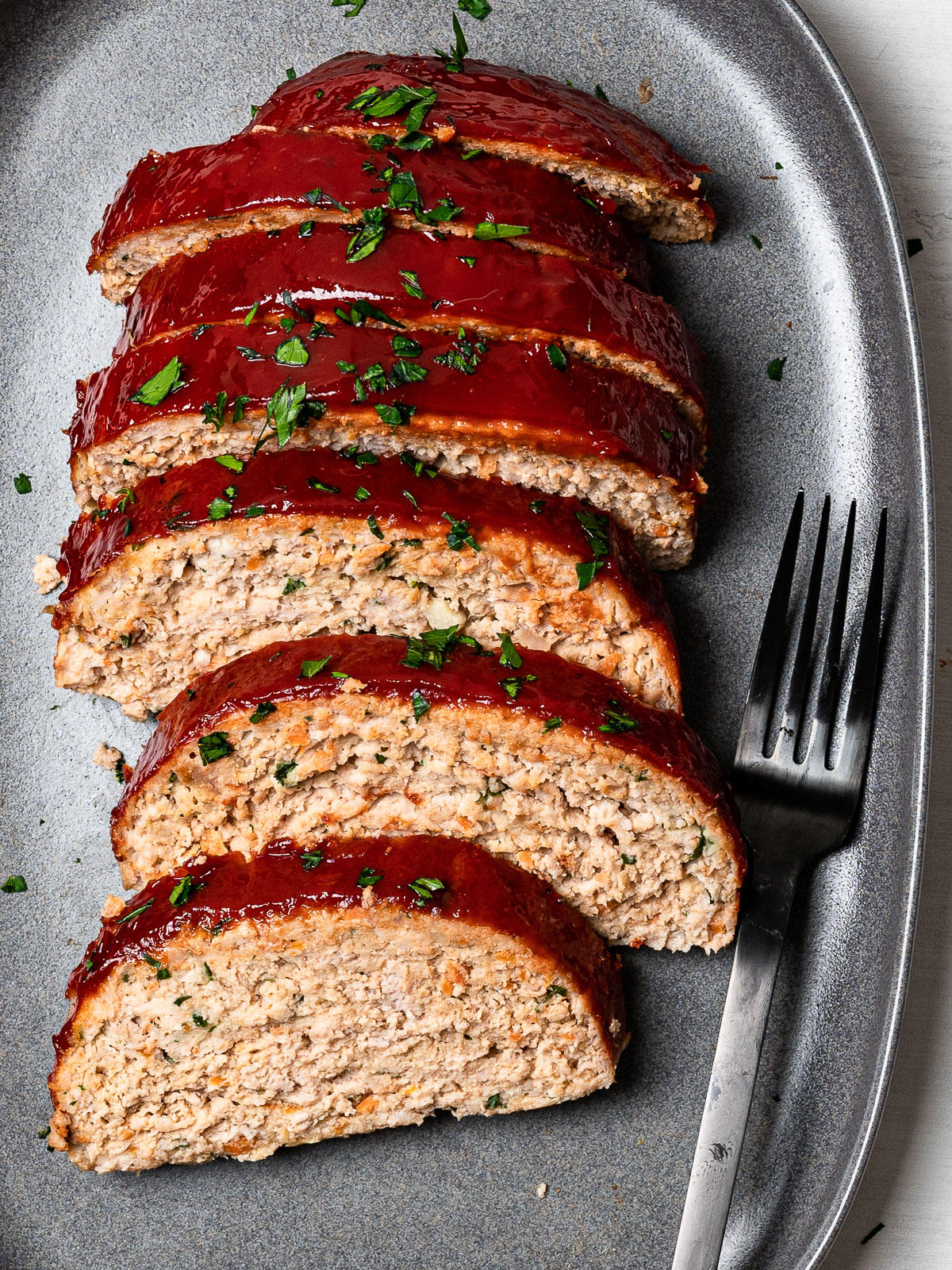 turkey meatloaf slices on platter with black fork for serving