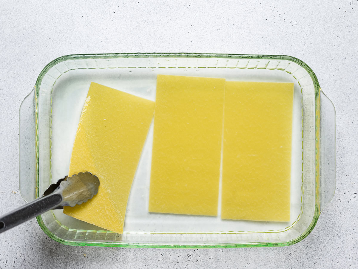 no-boil lasagna noodles soaking in baking dish filled with water