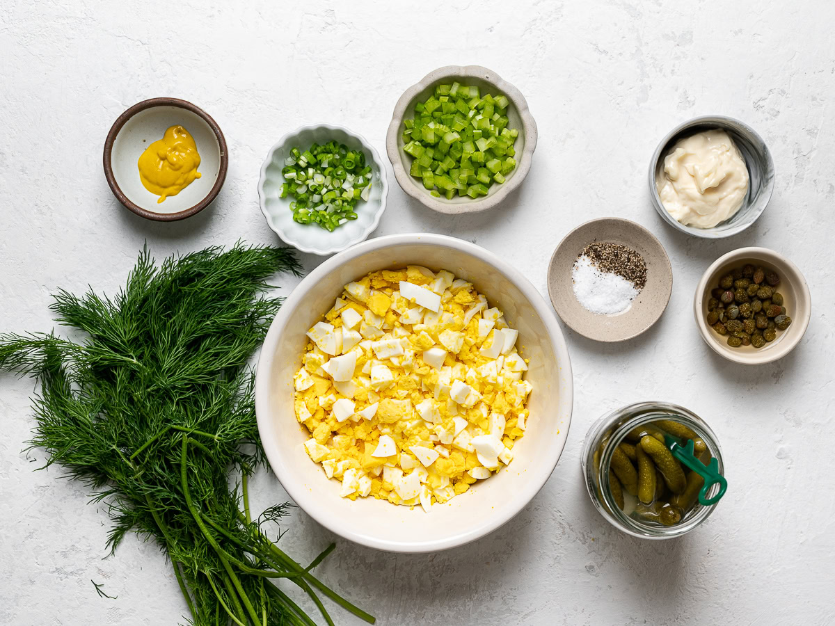 ingredients to make egg salad placed in small bowls