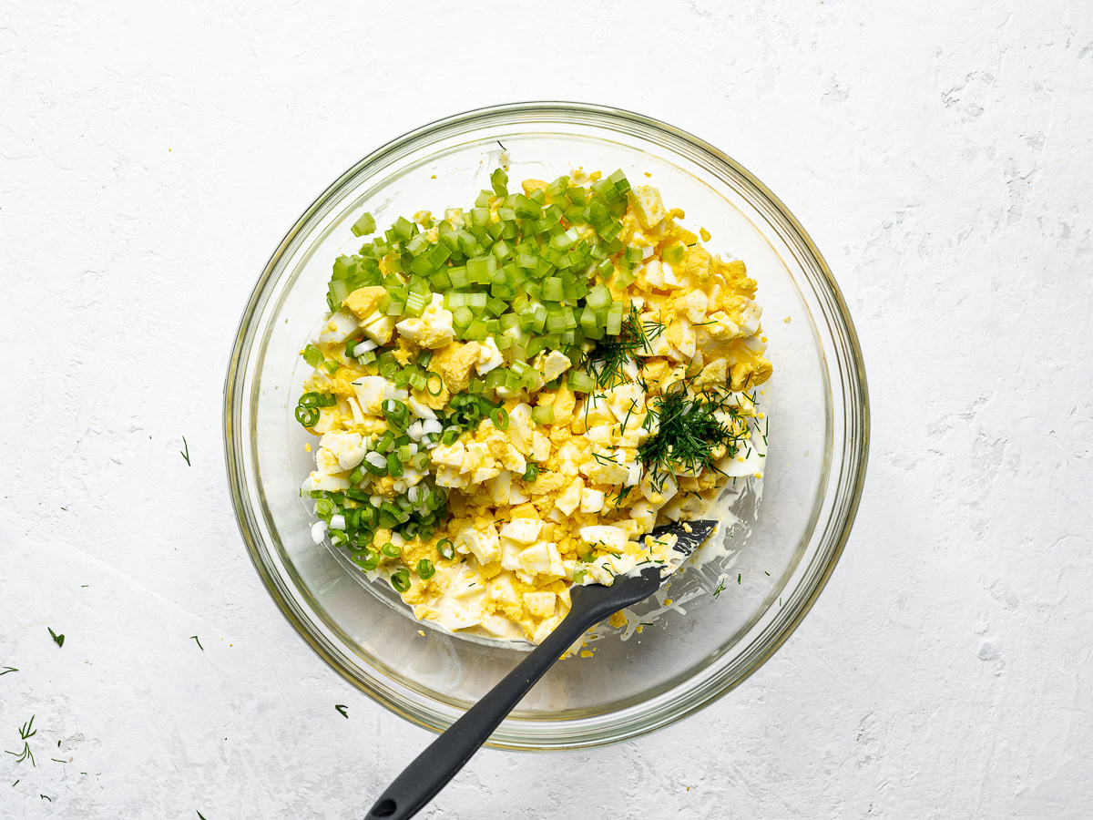 chopped hard boiled eggs with other ingredients in mixing bowl