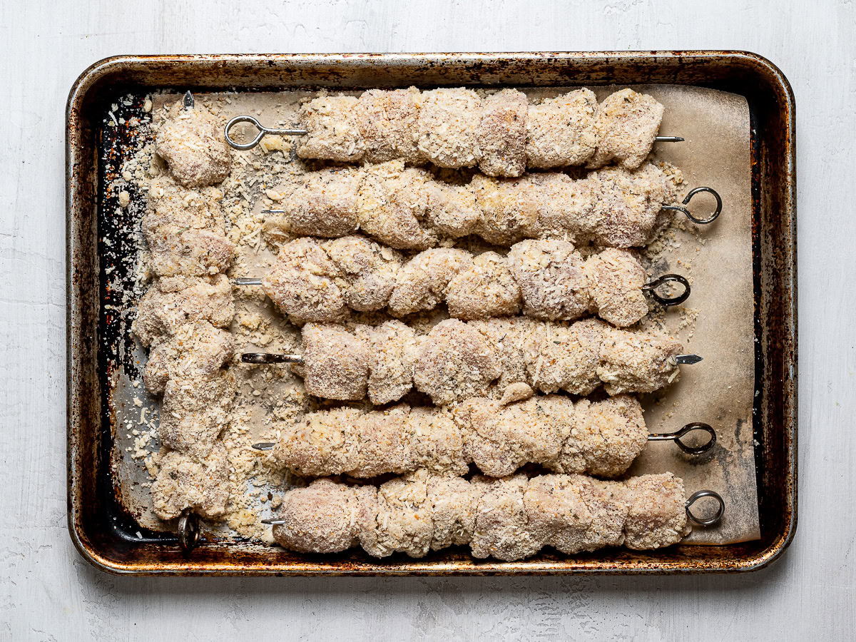 skewered chicken on baking sheet ready to be grilled