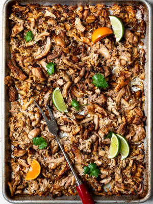 Crispy chicken carnitas on sheet pan with lemon wedges