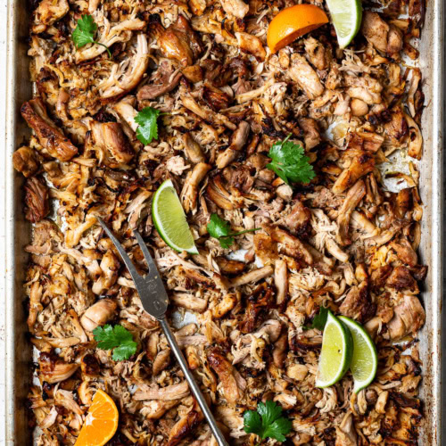 Crispy chicken carnitas on sheet pan with lemon wedges