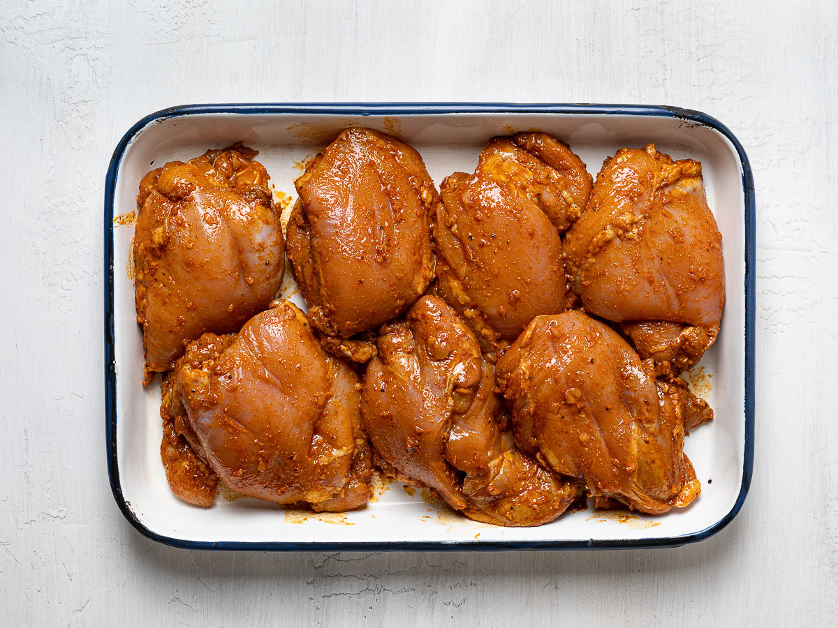 chicken thighs marinating in baking dish