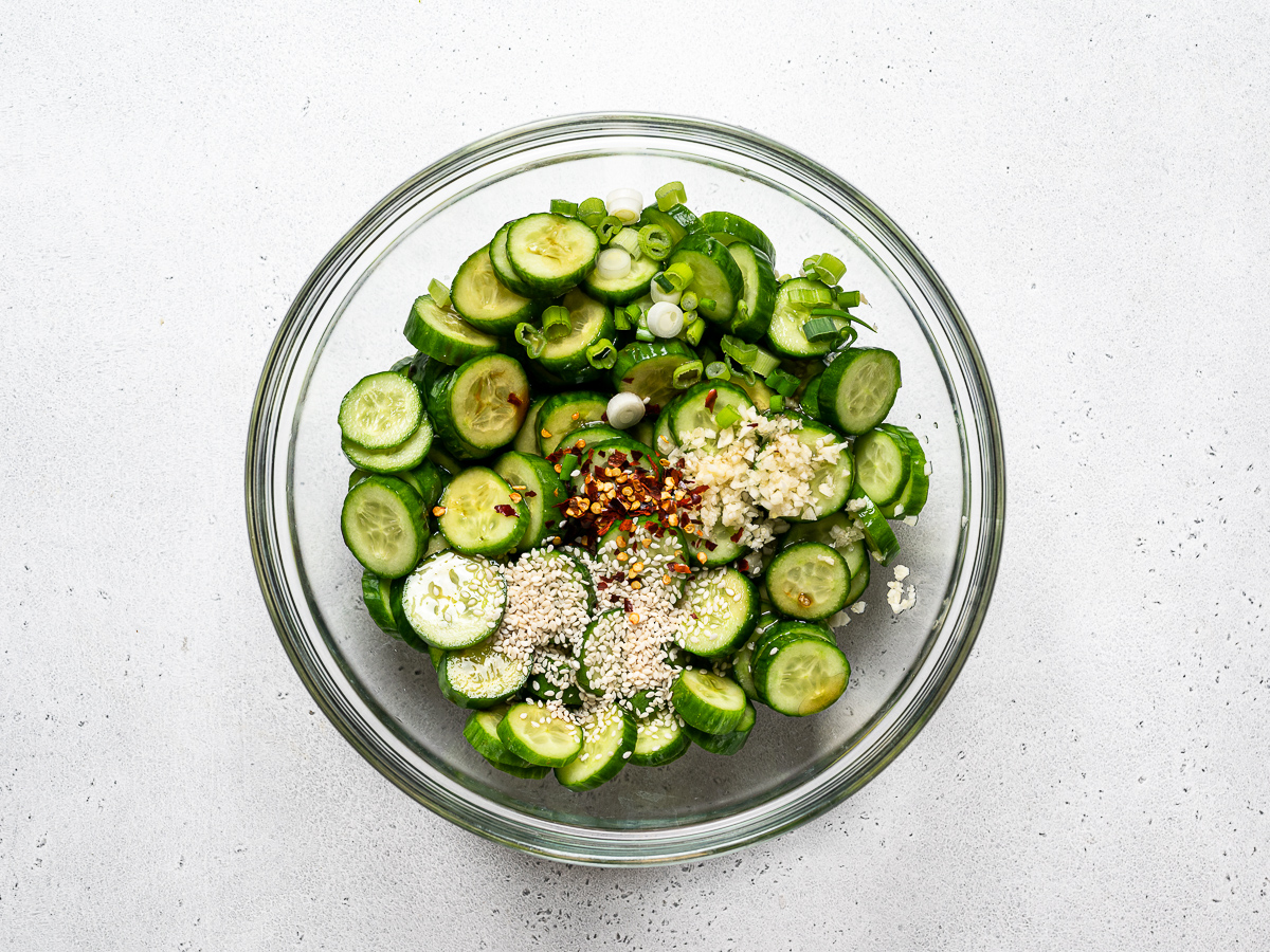 cucumbers in glass bowl with dressing