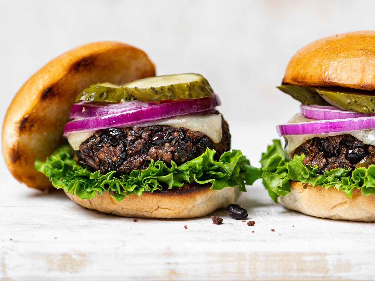 side view of two prepared burgers on a board