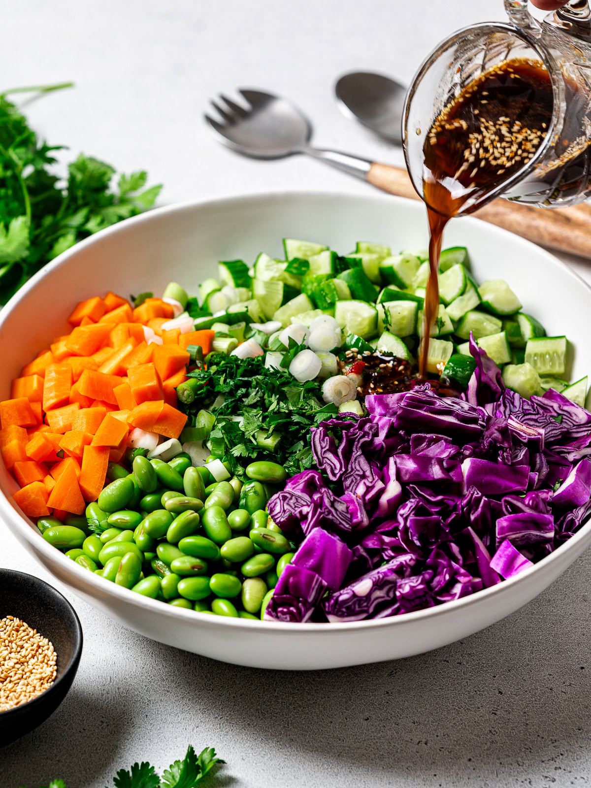 pouring dressing over chopped vegetables