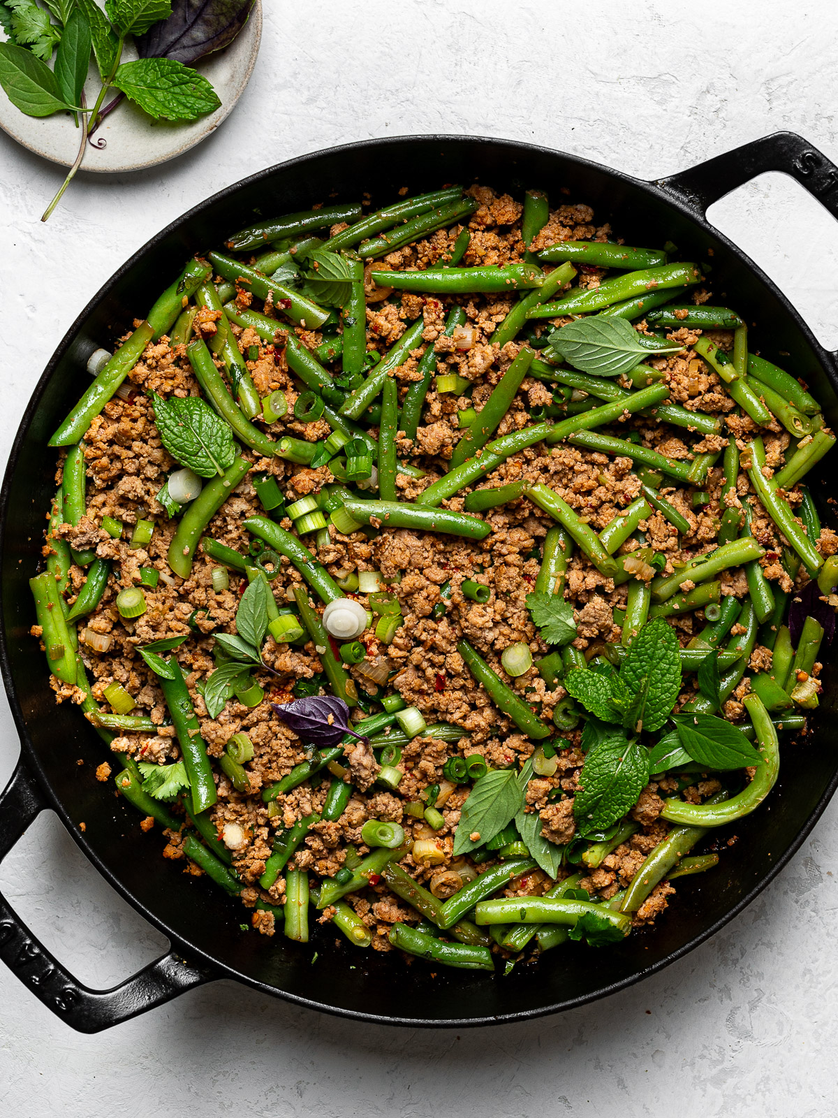 turkey and green bean stir-fry in skillet garnished with herbs