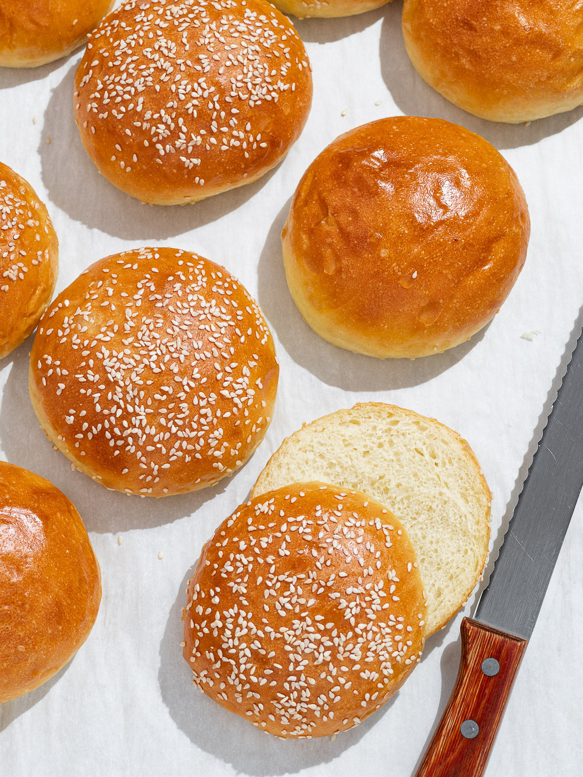 top view of hamburger buns with one bun sliced open 