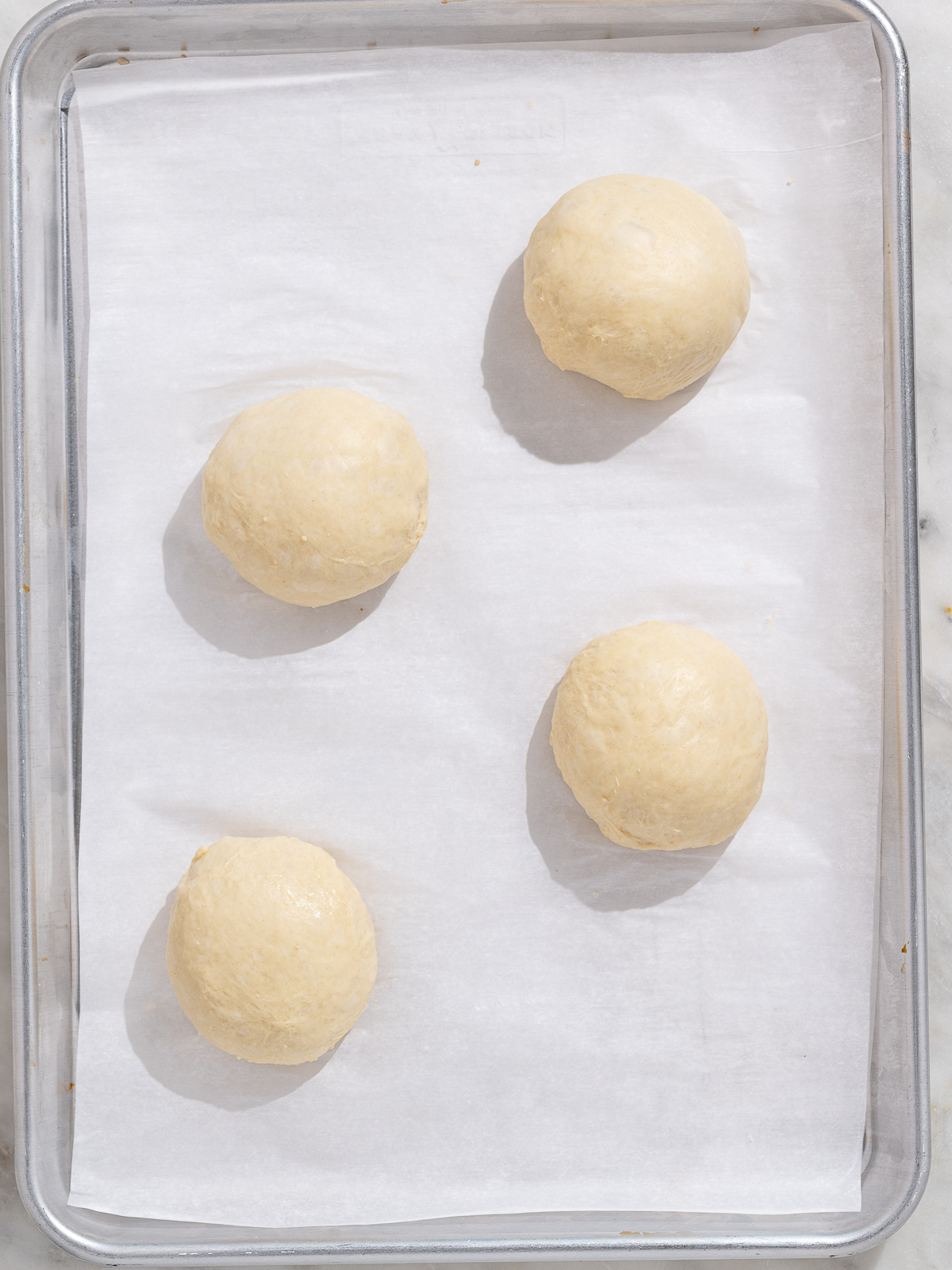 shaped dough balls on baking sheet before rising
