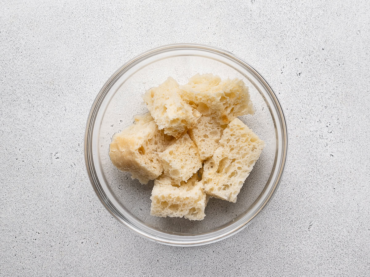 bread chunks in a small bowl soaking in water