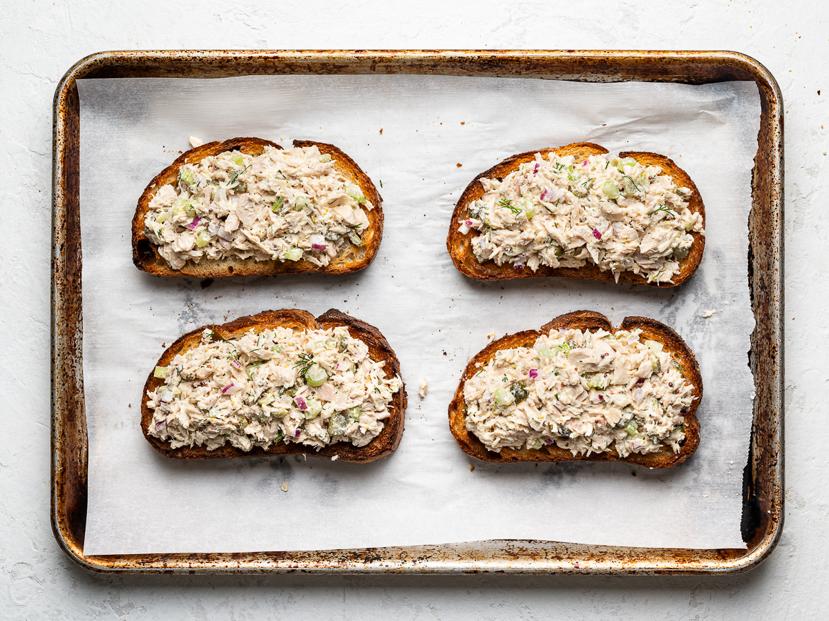 4 toasts on baking sheet topped with tuna salad