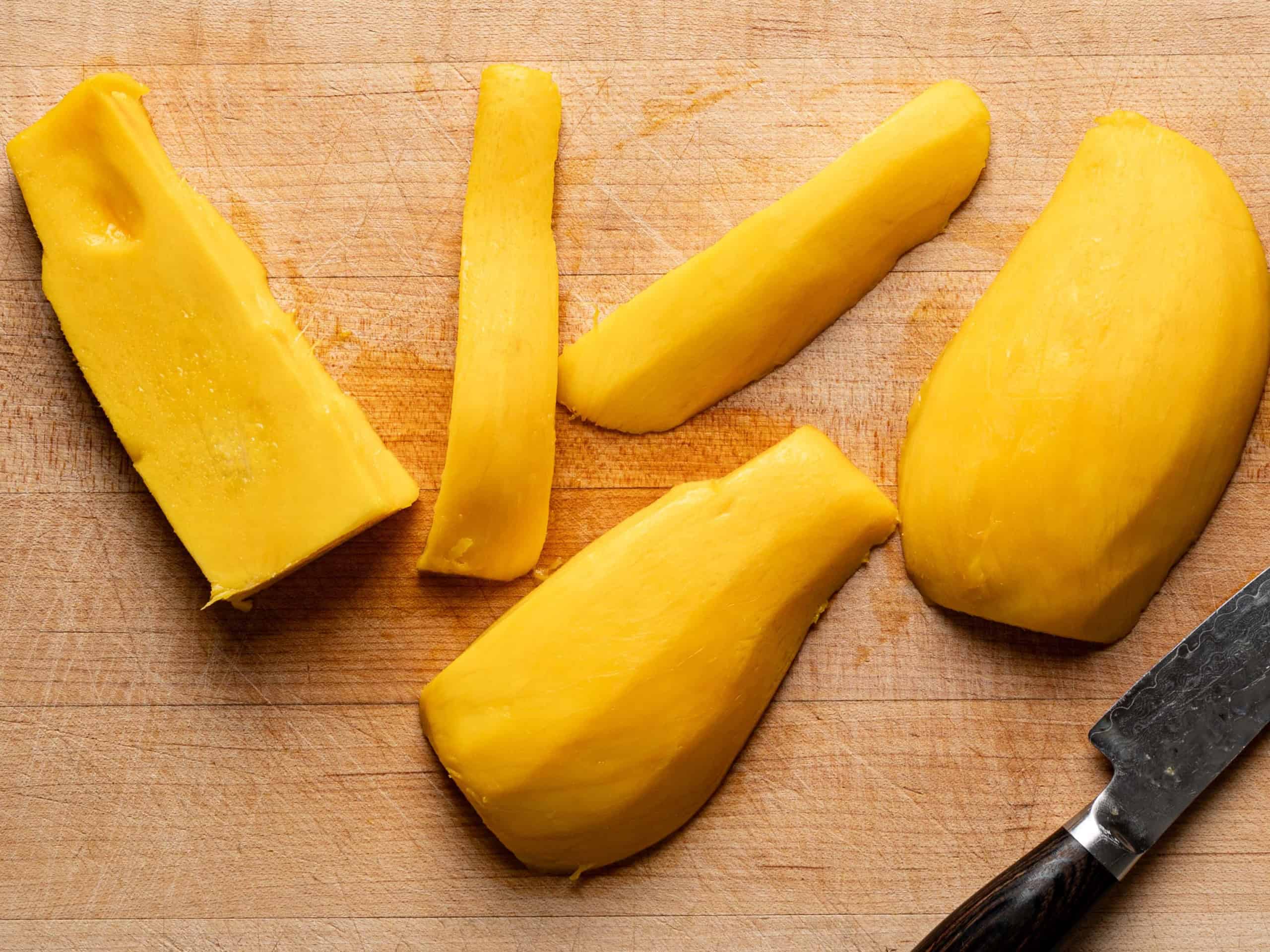 sliced planks of mango on cutting board