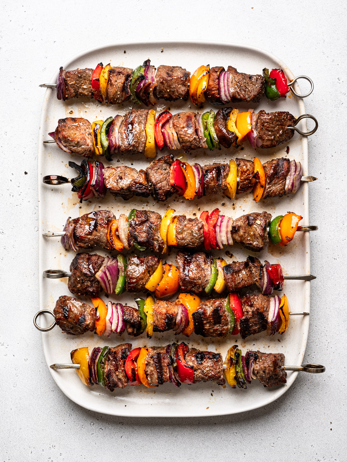 grilled shish kebobs lined horizontally on platter