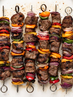 close up of grilled beef shish kebobs (cubes of beef on skewers with vegetables)