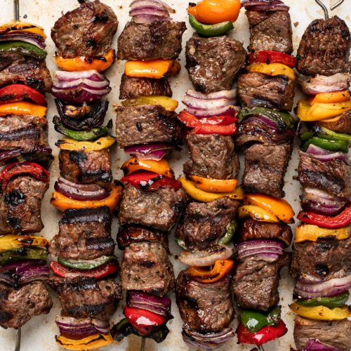 close up of grilled beef shish kebobs (cubes of beef on skewers with vegetables)