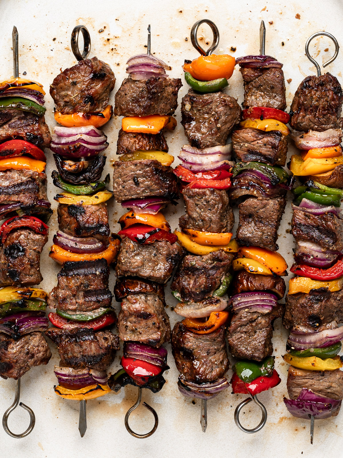 close up of grilled beef shish kebobs (cubes of beef on skewers with vegetables) 