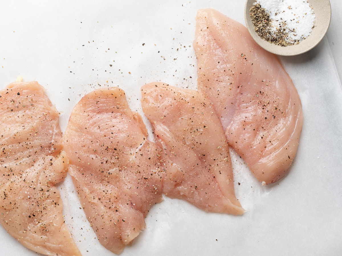 seasoning the chicken cutlets with salt and pepper