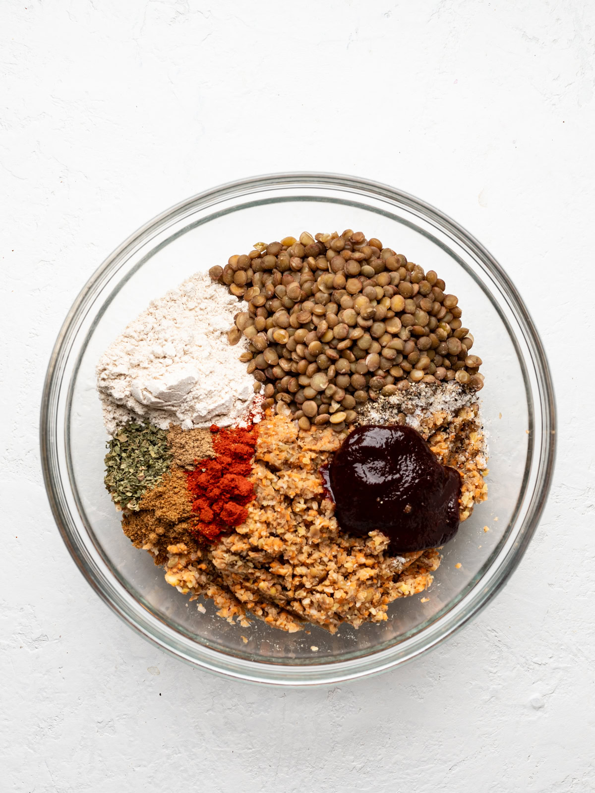 lentil mixture in mixing bowl with spices, oat flour and tomato paste 