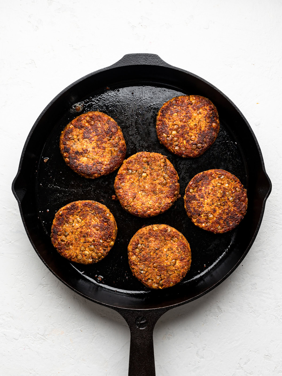 six lentil patties fried in skillet