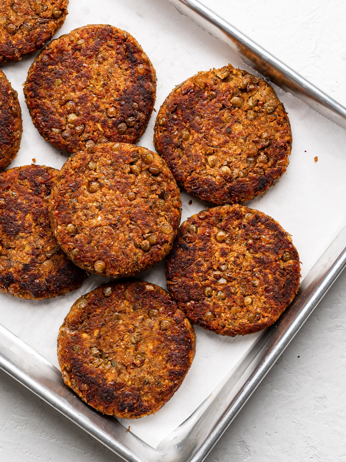 a pile of cooked lentil Patties on baking sheet