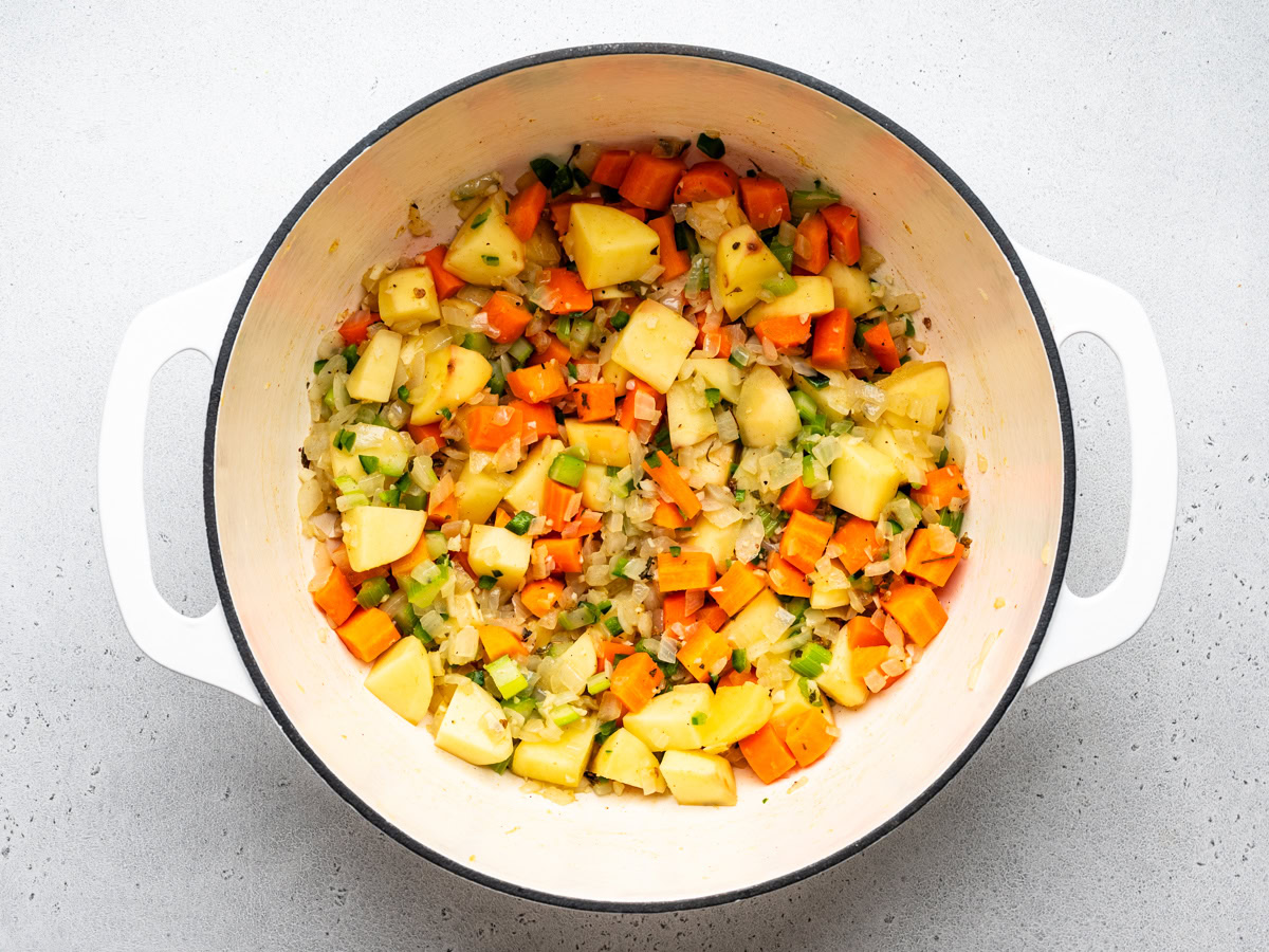 sautéed vegetables in a large white Dutch oven