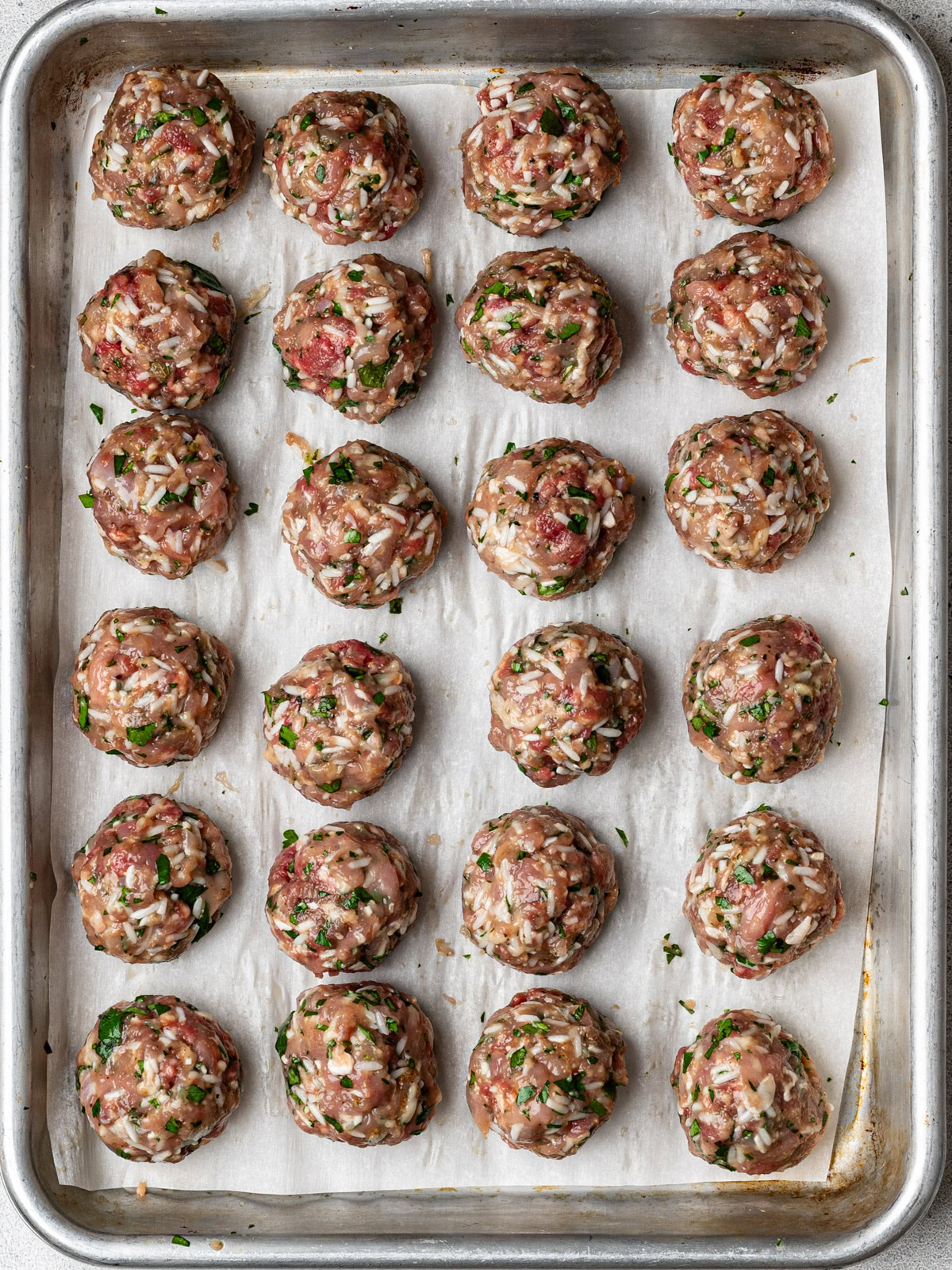 rolled meatballs on a small sheet pan