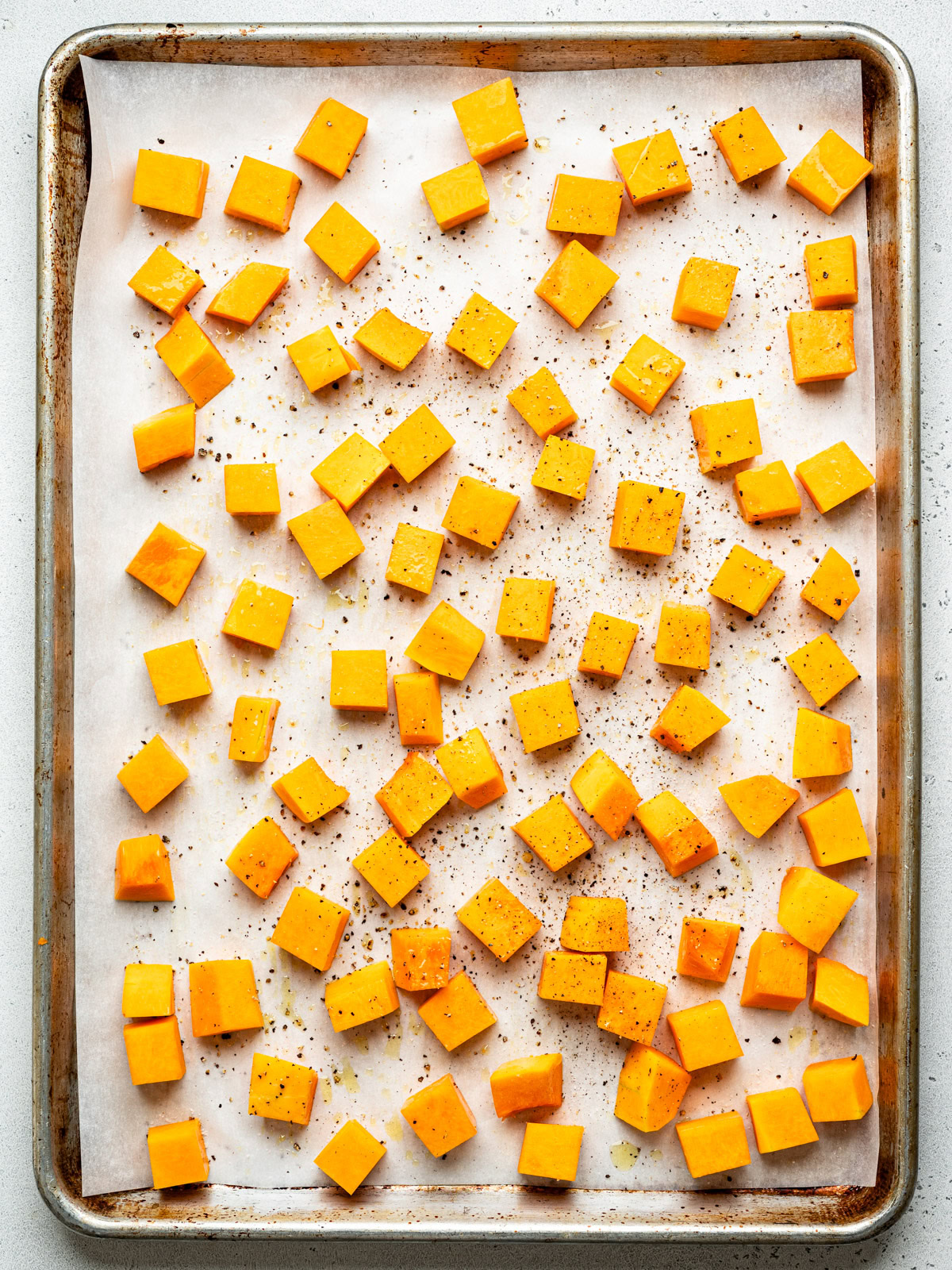 cubed butternut squash on sheet pan ready to be roasted
