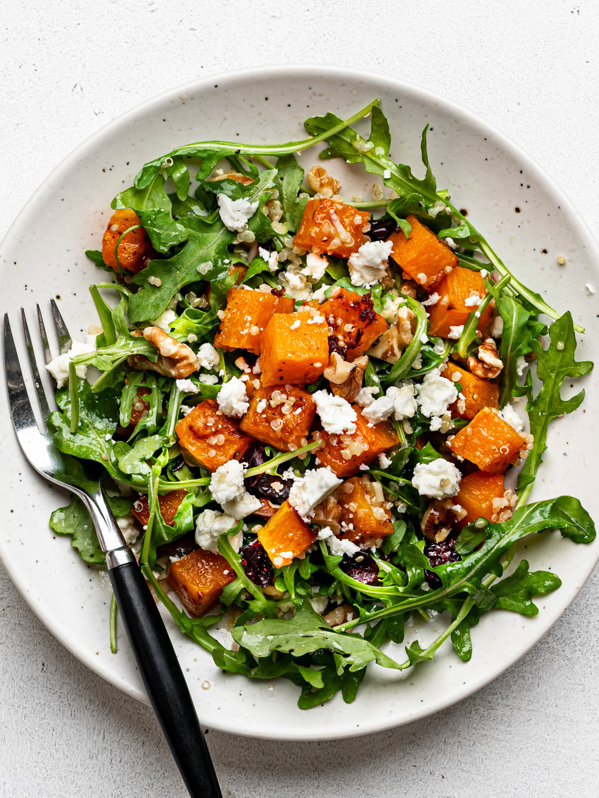 Butternut squash quinoa salad served on a small plate with a fork