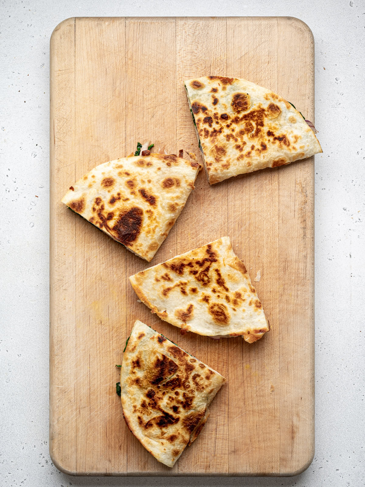 4 quesadilla triangles on cutting board