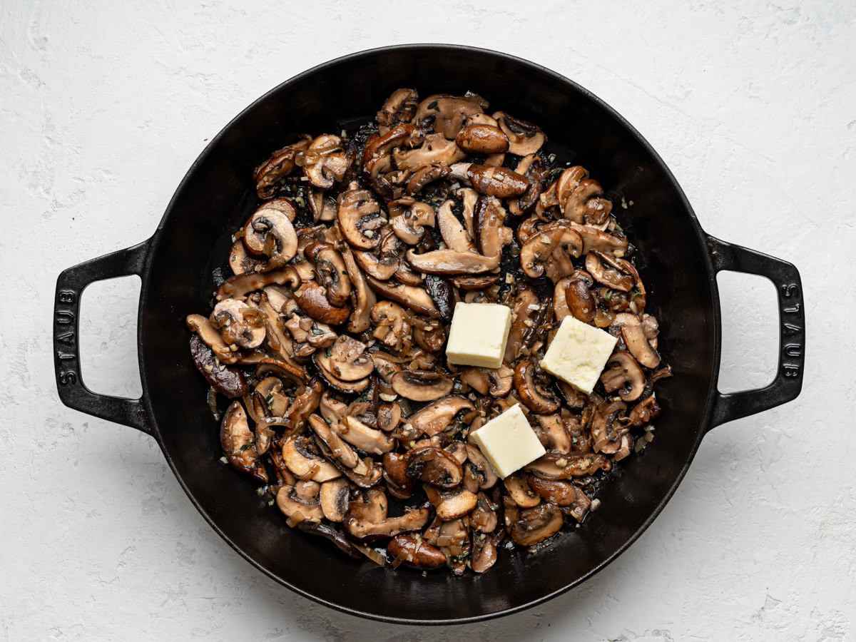 sautéed mushrooms and shallots in black skillet with 3 tablespoons of butter added