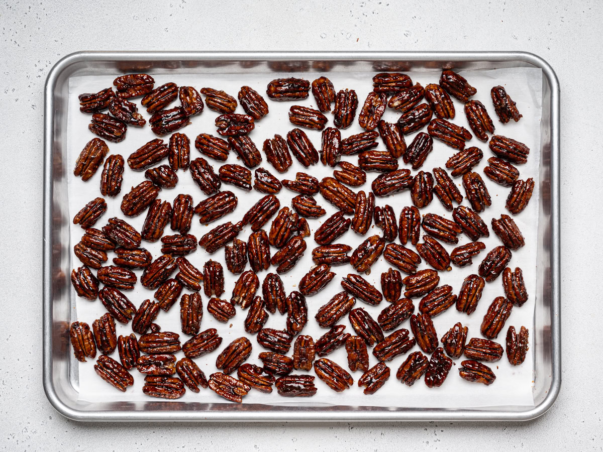 glazed pecans spread out in baking sheet