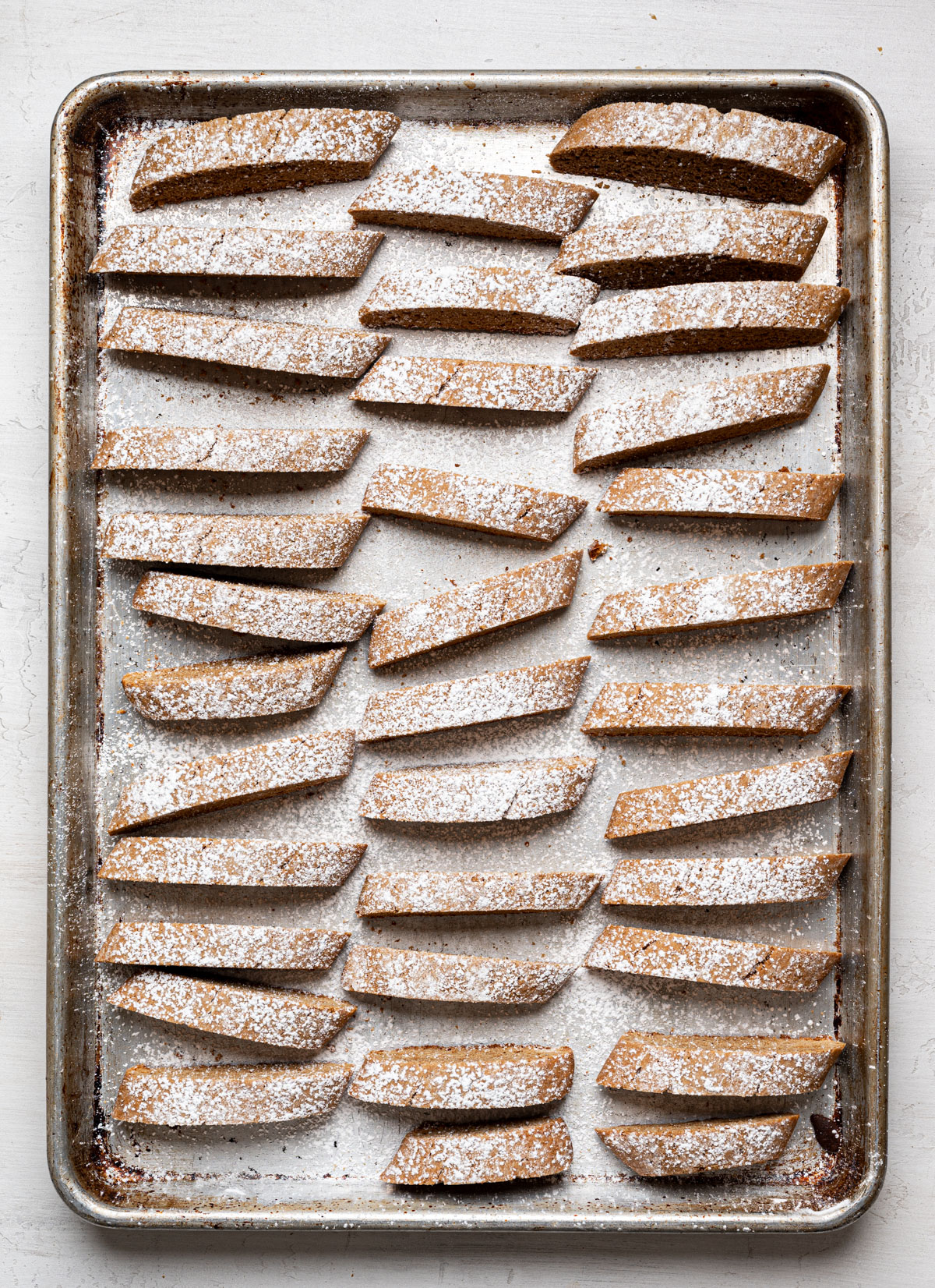 sliced biscotti placed standing up on baking sheet for second bake