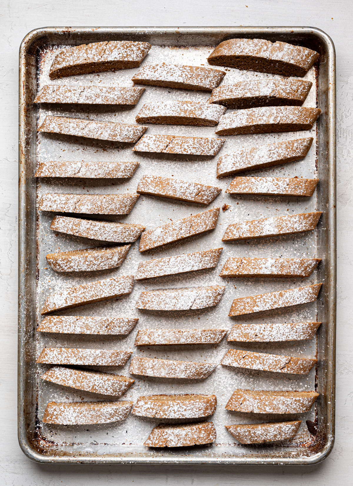 sliced biscotti placed standing up on baking sheet for second bake