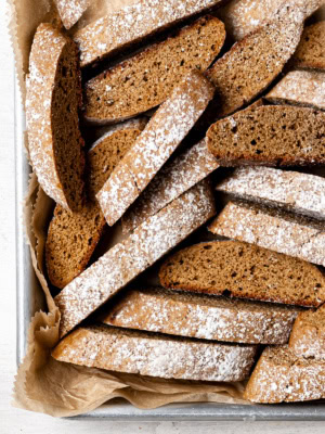 many gingerbread biscotti in a sheet pan lined with parchment paper