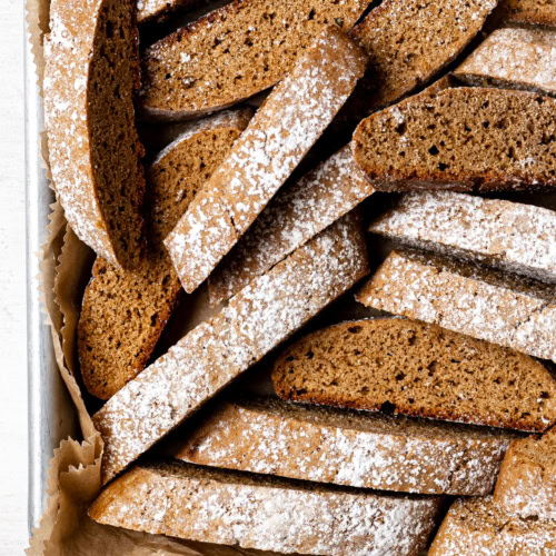 many gingerbread biscotti in a sheet pan lined with parchment paper