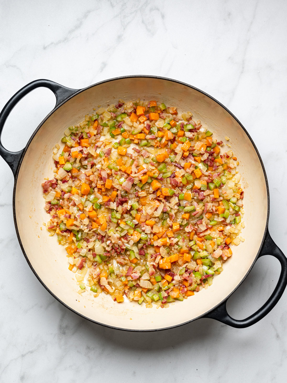 cooking chopped onion, celery, and carrots in large black skillet